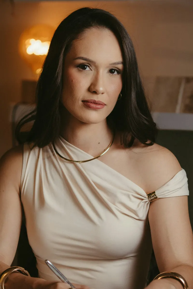 Portrait of a woman with long dark hair in a beige top